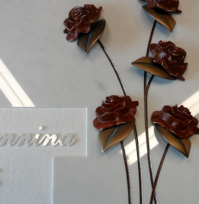 Epigrafe in Rilevo su lapide in Marmo con Rose applicate in bronzo